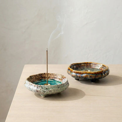 Artisan kiln-fired ceramic incense burners on a wooden table, showcasing unique transmutation glaze patterns.