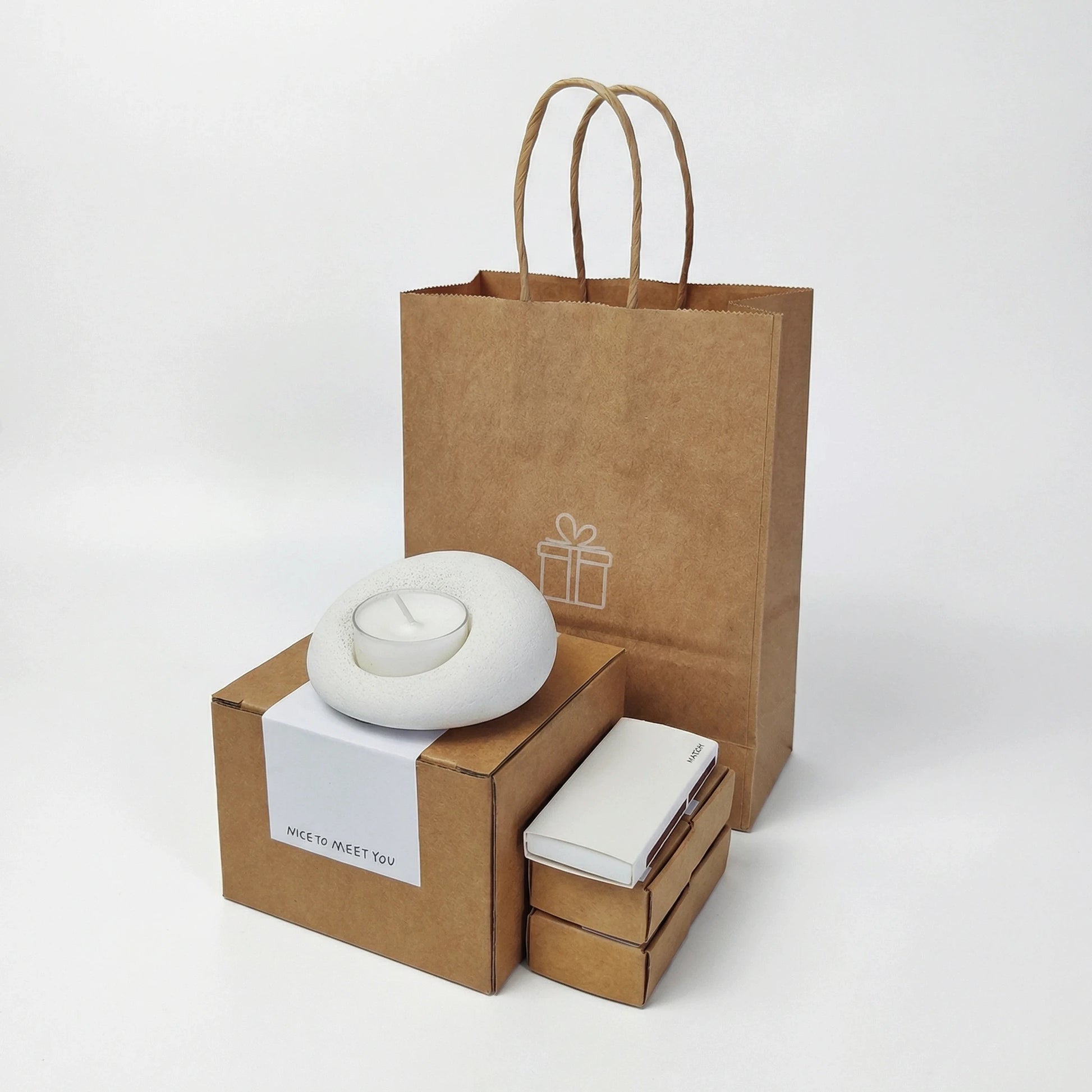 Eco-friendly gift packaging for stone candle holder, including a kraft paper bag and a box with a 'Nice to meet you' label.