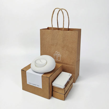 Eco-friendly gift packaging for stone candle holder, including a kraft paper bag and a box with a 'Nice to meet you' label.