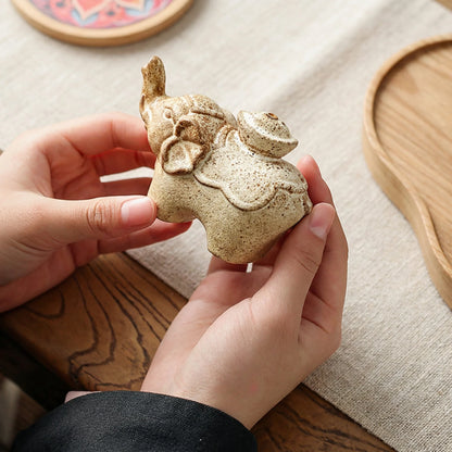 Hand holding a small ceramic elephant incense holder to show the handmade pottery detail and actual size