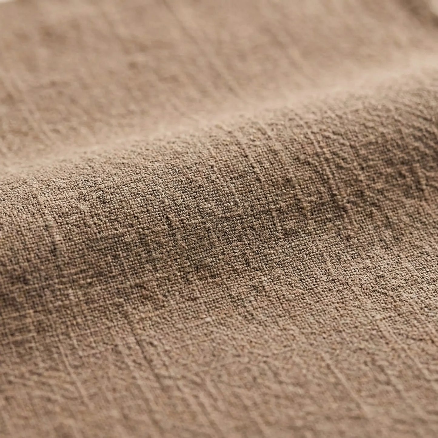 Macro view of a natural oatmeal-colored cotton linen fabric, emphasizing the soft ripples and anti-static woven material