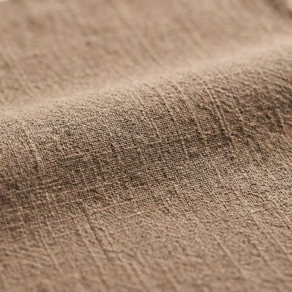 Macro view of a natural oatmeal-colored cotton linen fabric, emphasizing the soft ripples and anti-static woven material
