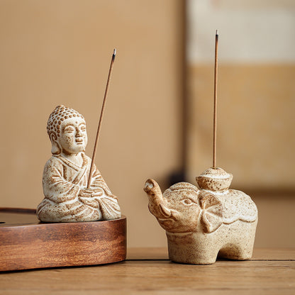 Pair of wabi-sabi style ceramic incense burners including a meditating monk and a baby elephant