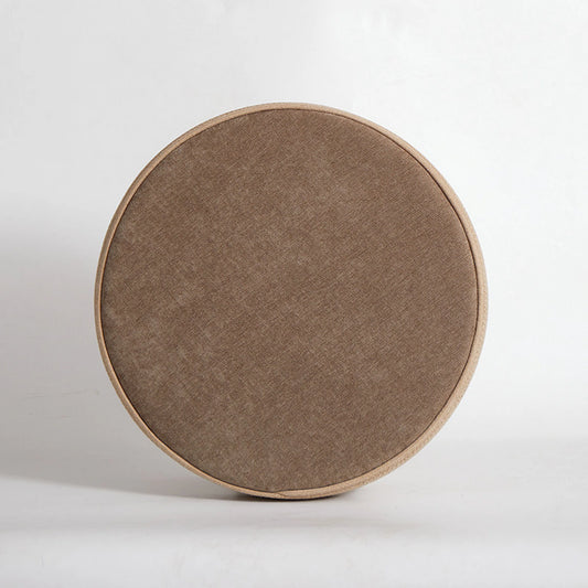 Front view of a minimalist round floor cushion in oatmeal beige with a matching light-colored braided rope trim on a white background.